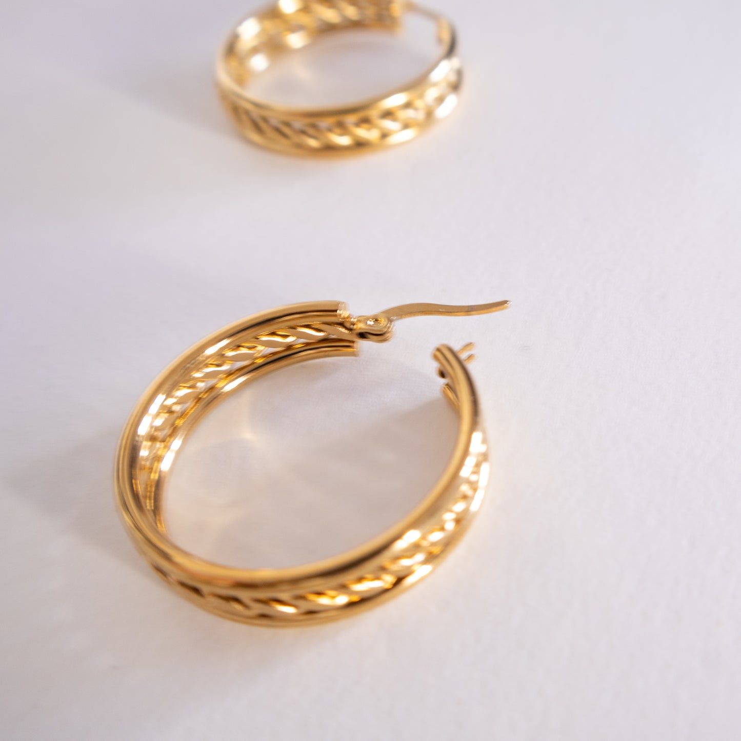 Gold hoop earrings on a light gray background