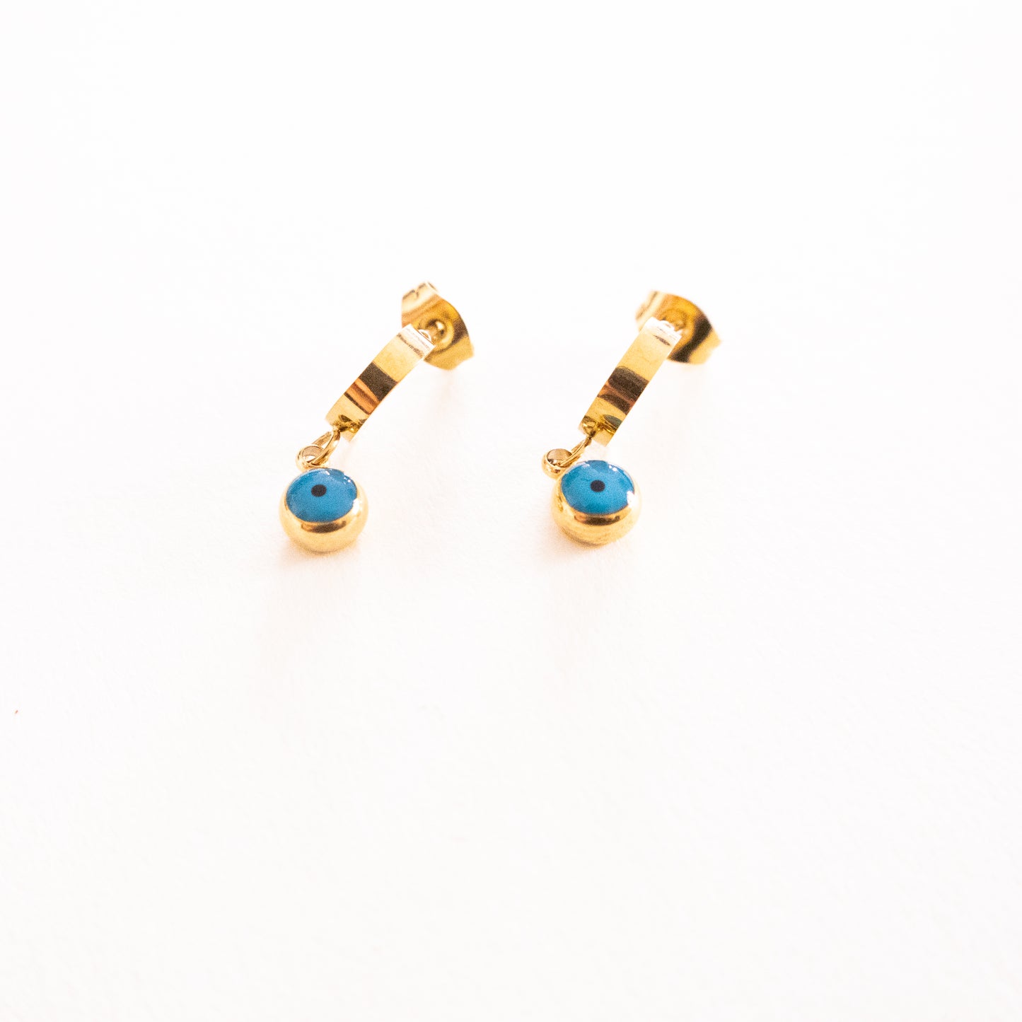 Gold earrings with blue stones on a white background