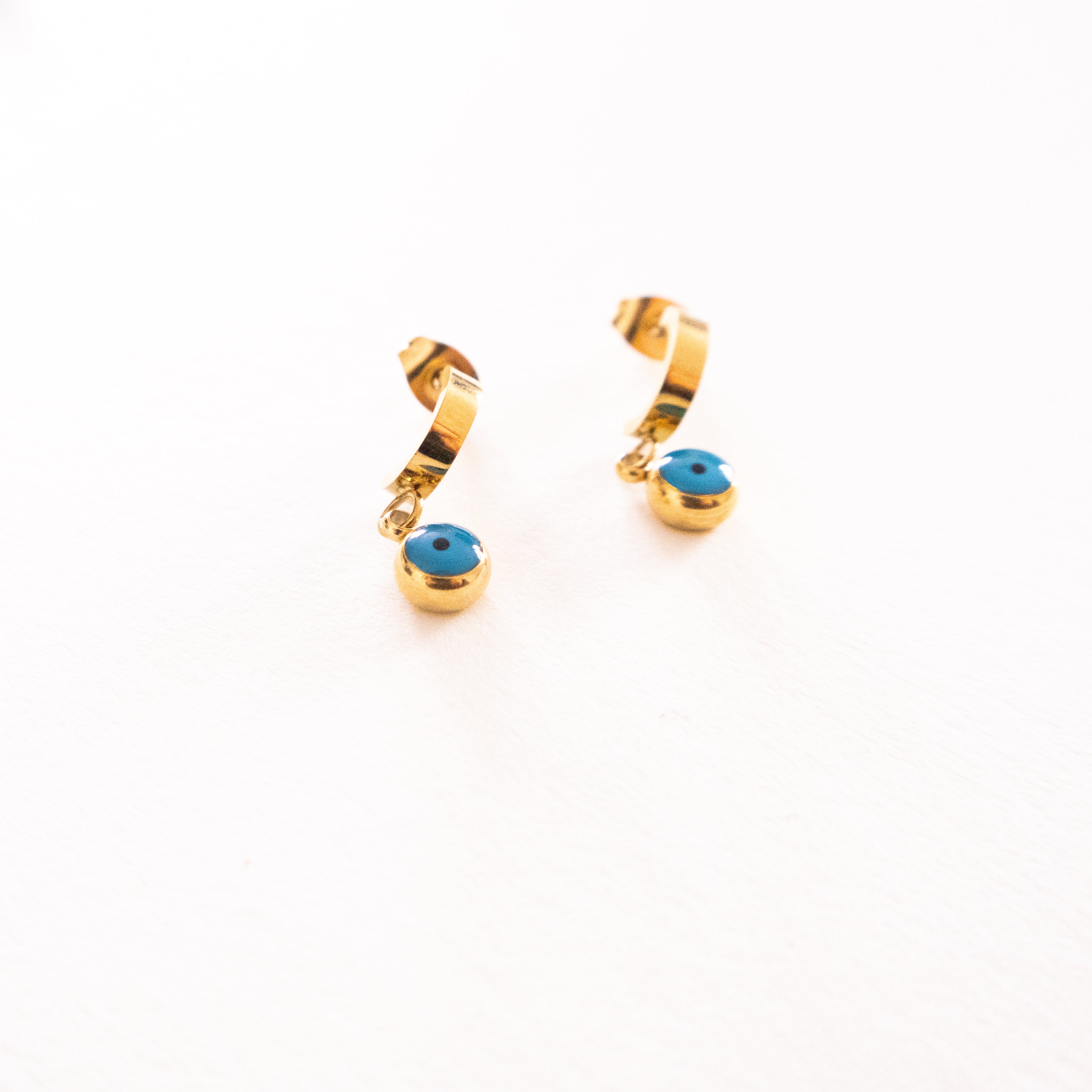 Gold hoop earrings with turquoise stones on a white background