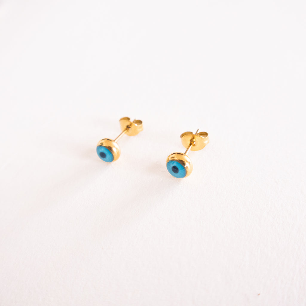 Gold earrings with blue stones on a white background