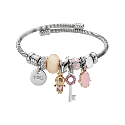 Silver bracelet with various charms on a white background