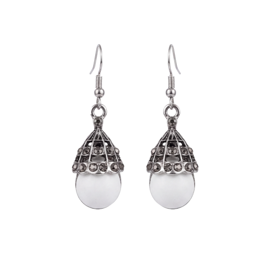 A pair of silver-toned drop earrings with a teardrop-shaped filigree top and a smooth oval white stone pendant, shown on a plain white background.