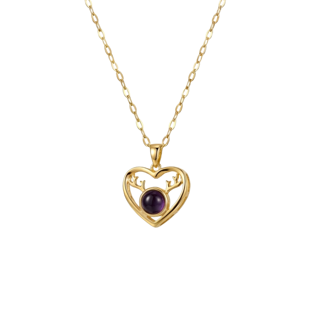 Gold heart-shaped necklace with a purple gemstone on a white background