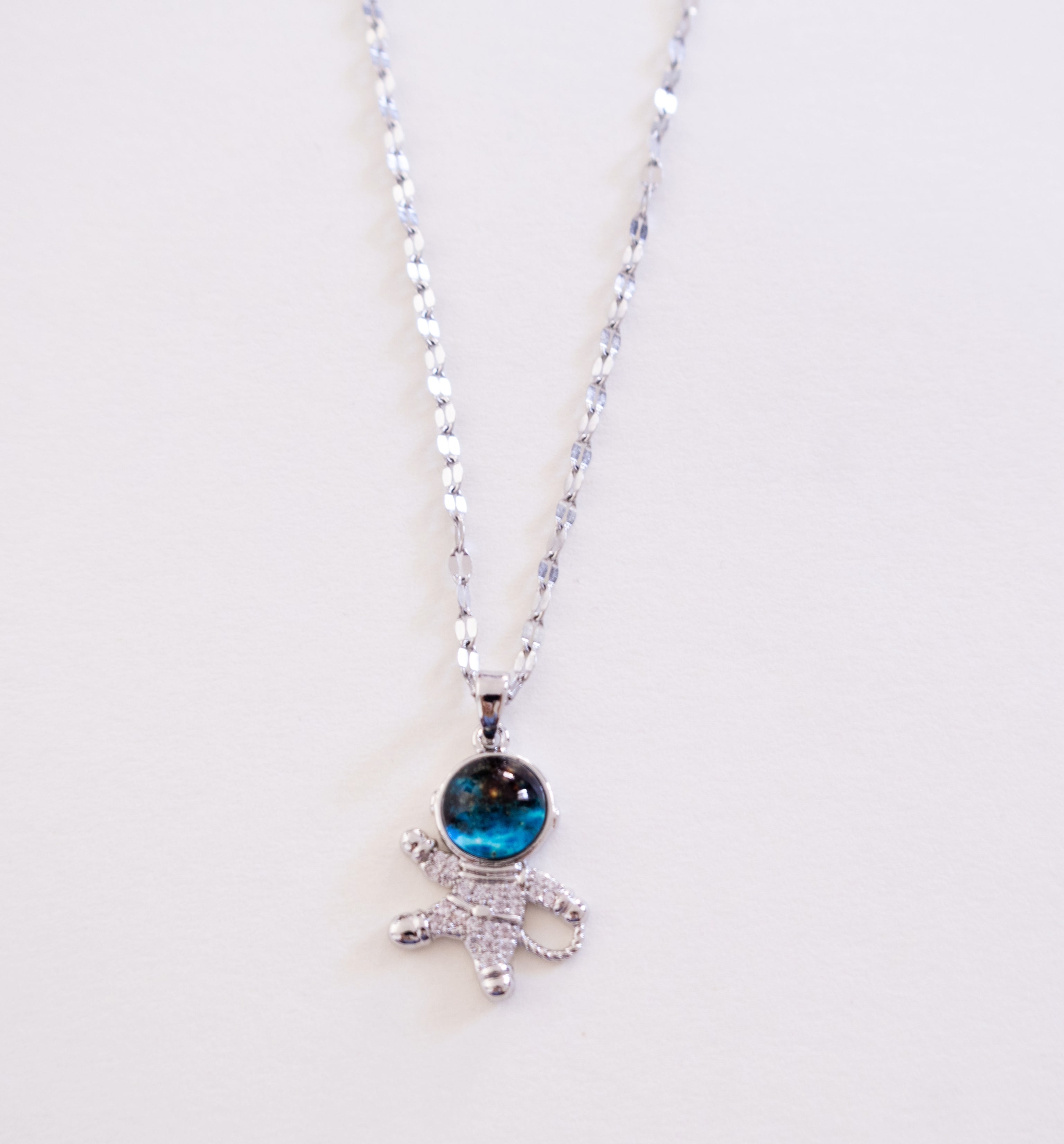 Necklace with a blue gemstone pendant on a white background