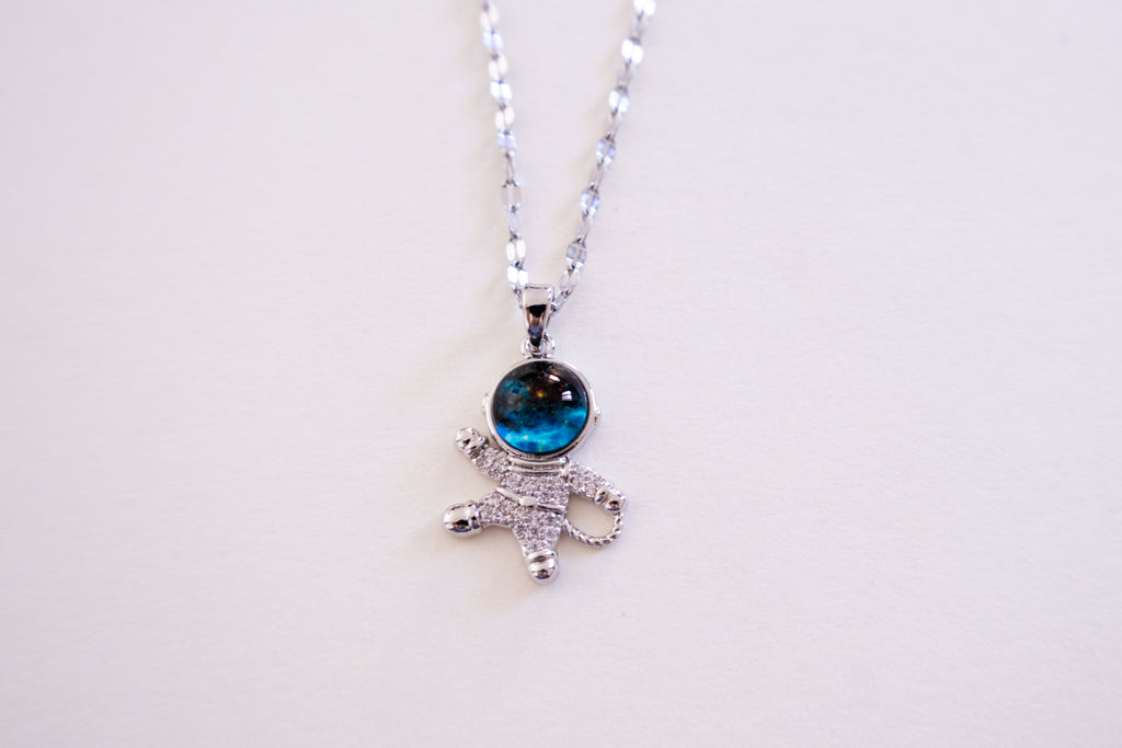 Silver necklace with a blue gemstone pendant on a white background