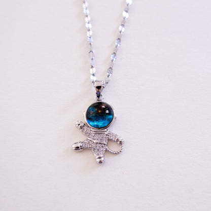 Silver necklace with a blue gemstone pendant on a white background