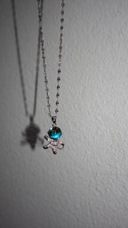 Necklace with a blue gem and bow pendant on a white background