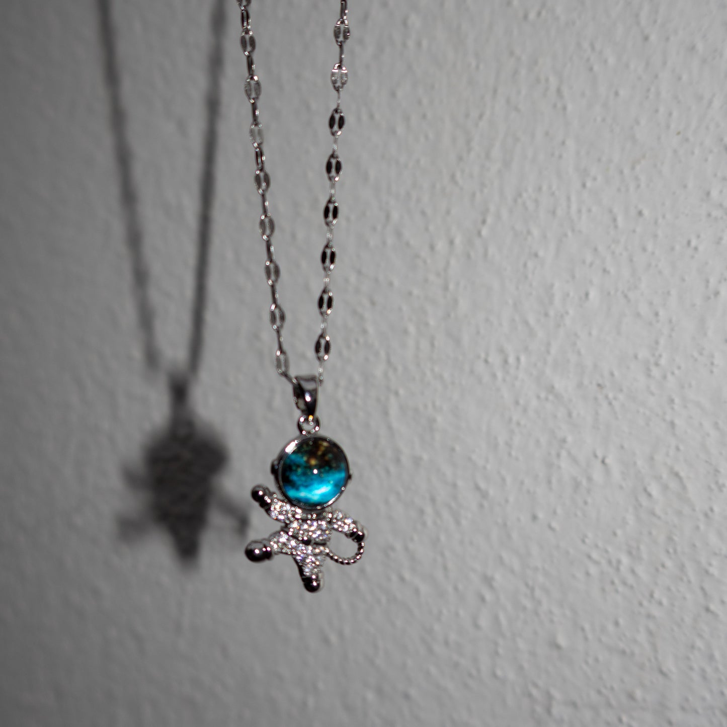 Necklace with a blue gem and bow pendant on a white background
