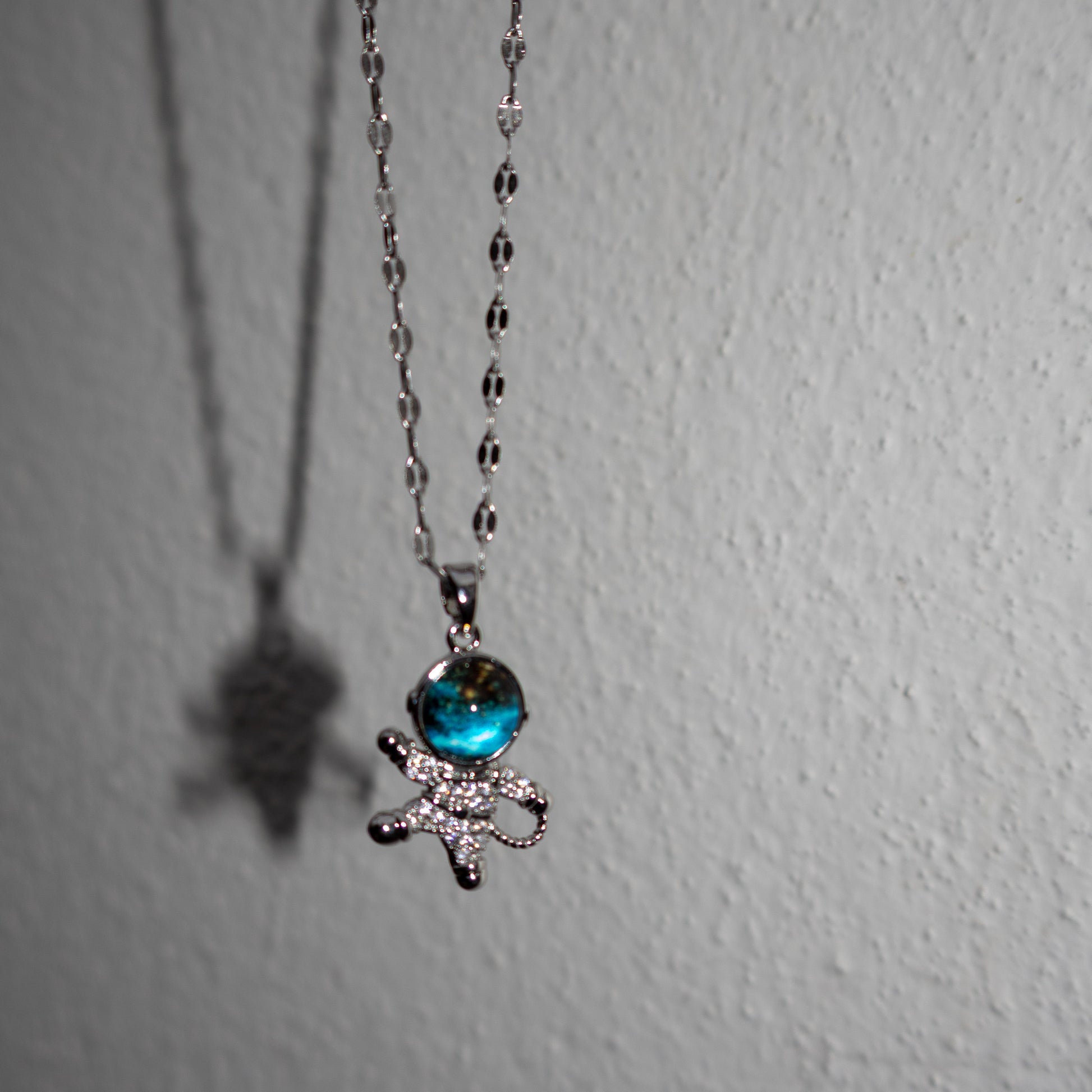 Necklace with a blue gem and bow pendant on a white background