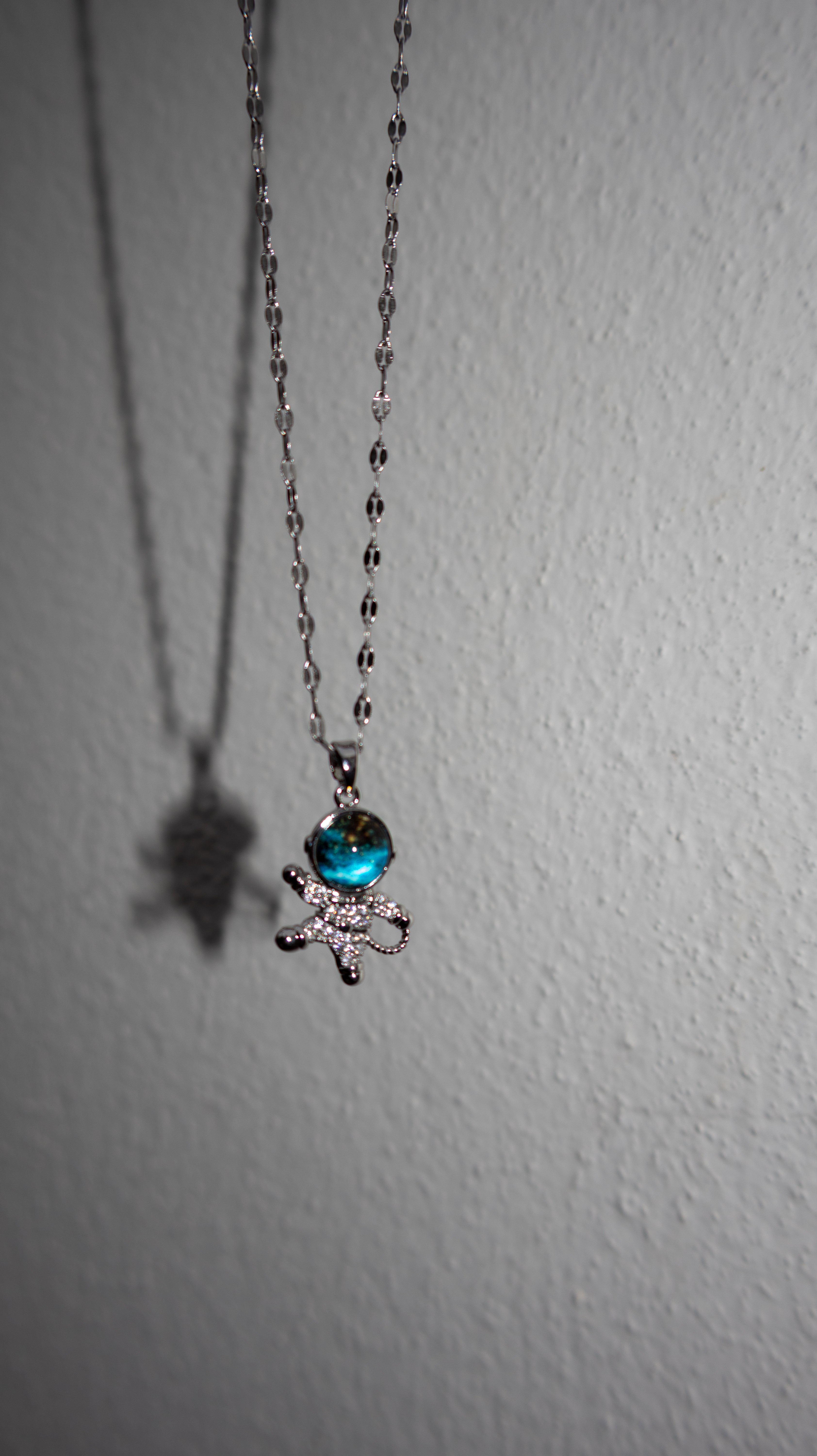 Necklace with a blue gem and bow pendant on a white background