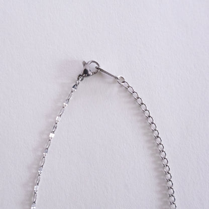 Close-up of a silver chain bracelet on a light gray background
