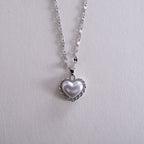 Close-up of a silver chain with black leather straps on a white background