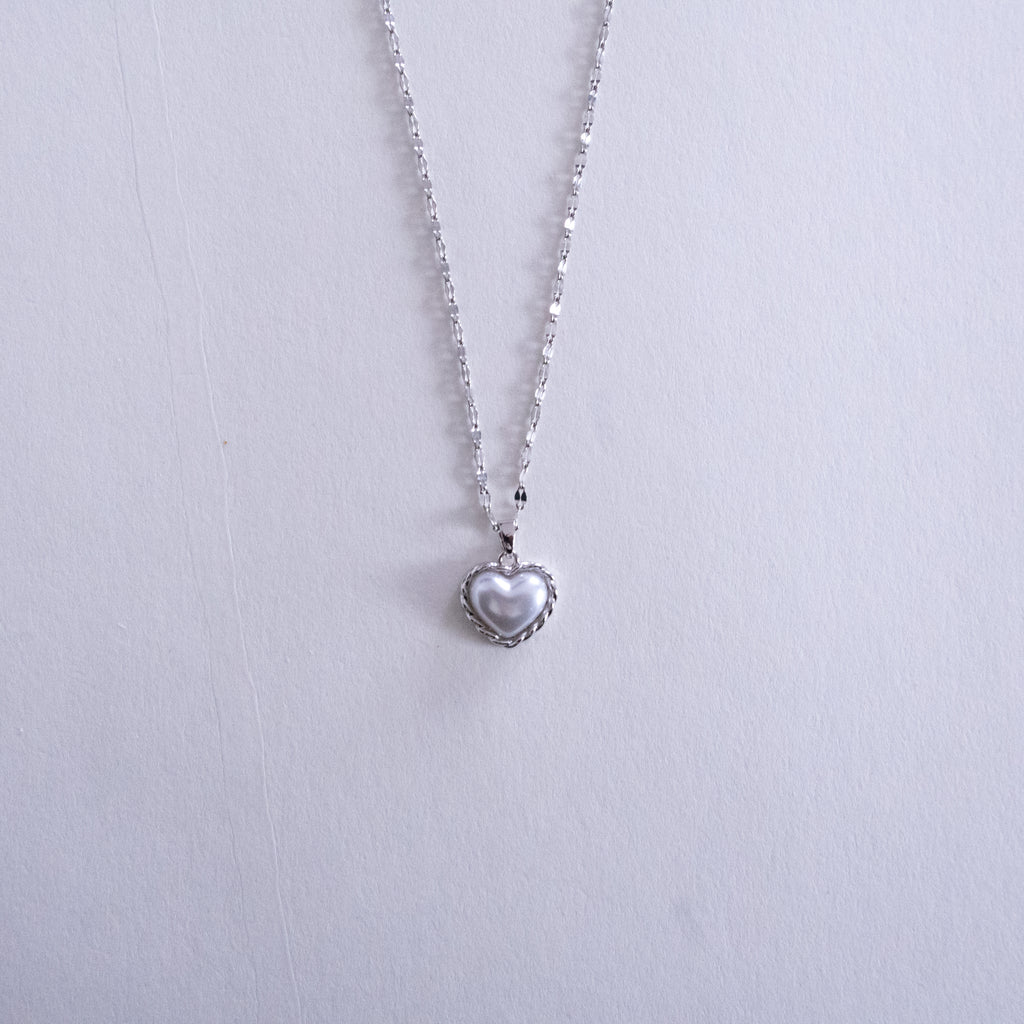 Heart-shaped pendant necklace on a light gray background