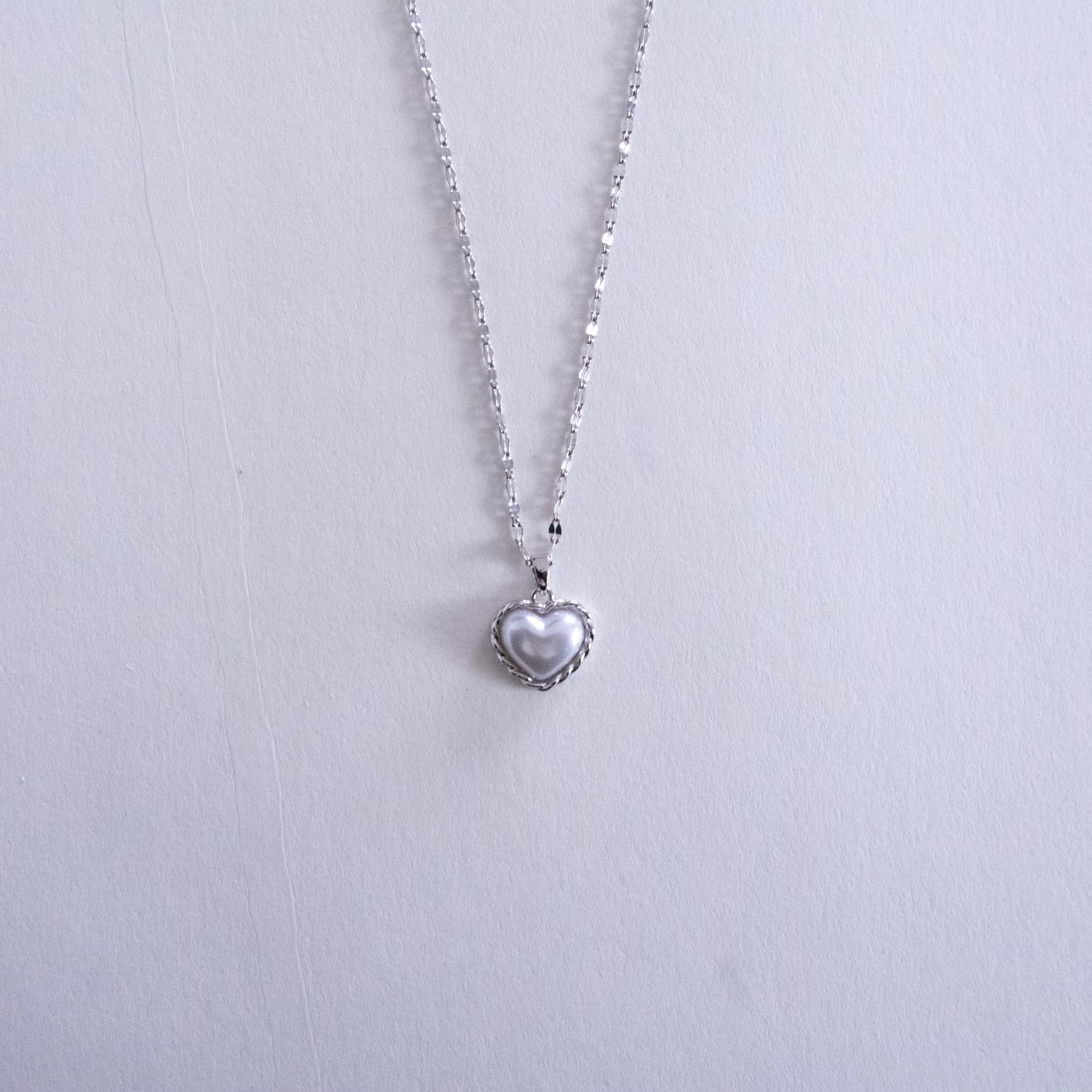 Heart-shaped pendant necklace on a light gray background