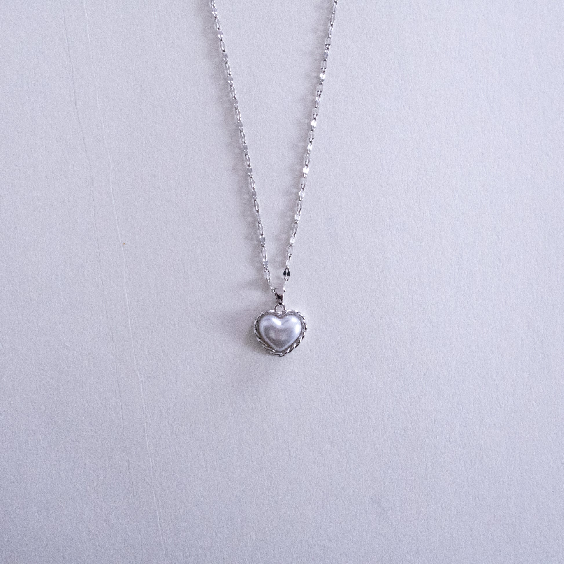 Heart-shaped pendant necklace on a light gray background