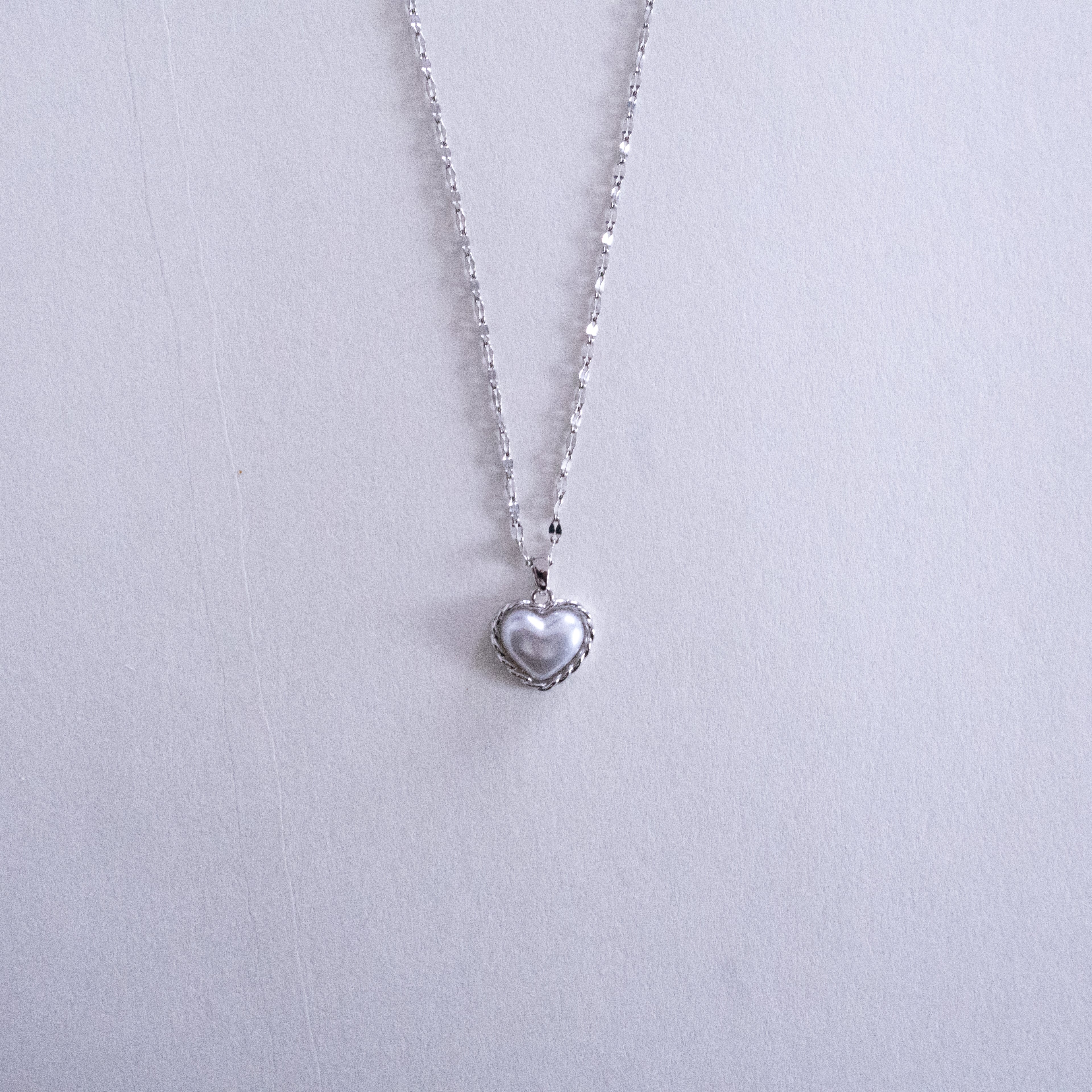 Heart-shaped pendant necklace on a light gray background