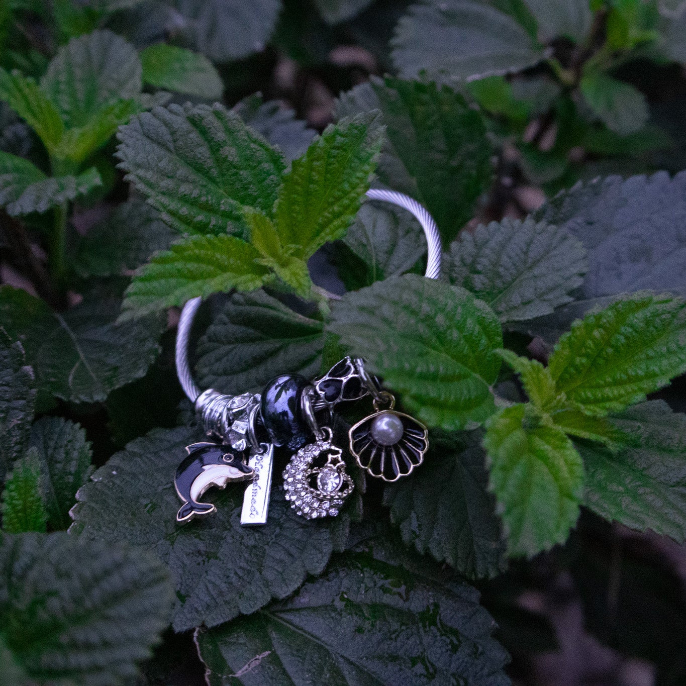 Bracelet with charms on a leafy green background