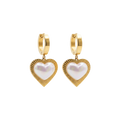 Gold heart-shaped earrings with pearl center on a white background