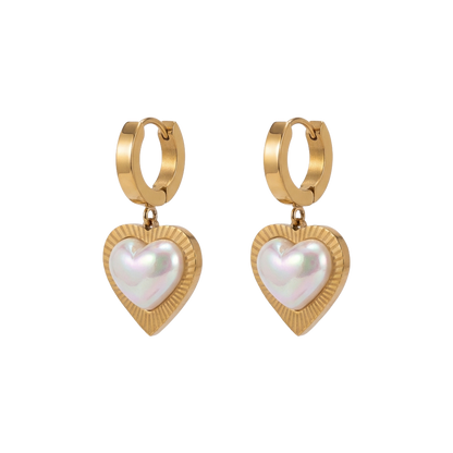 Gold hoop earrings with heart-shaped pearl drops on a white background