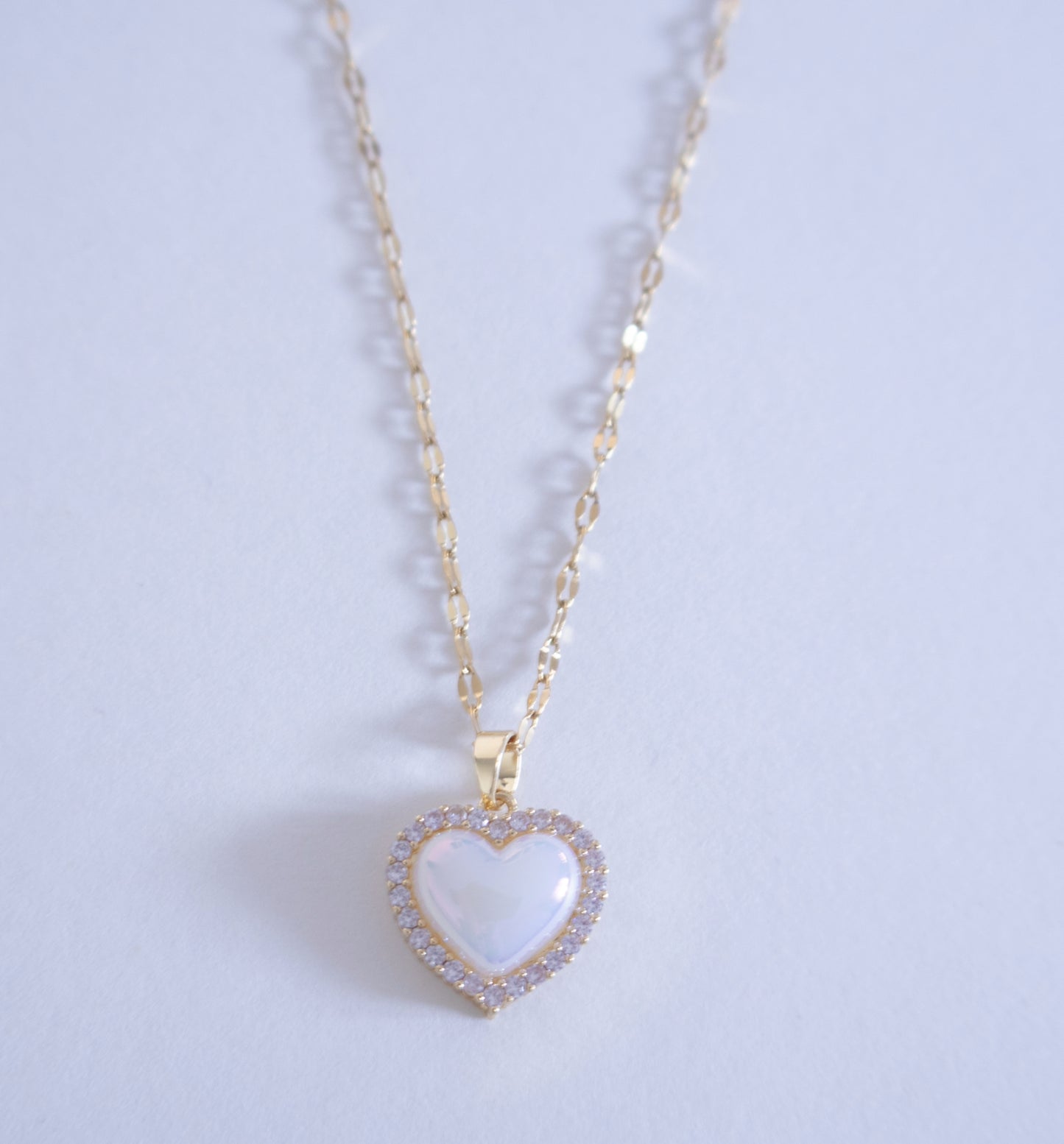 Heart-shaped pendant necklace on a light purple background