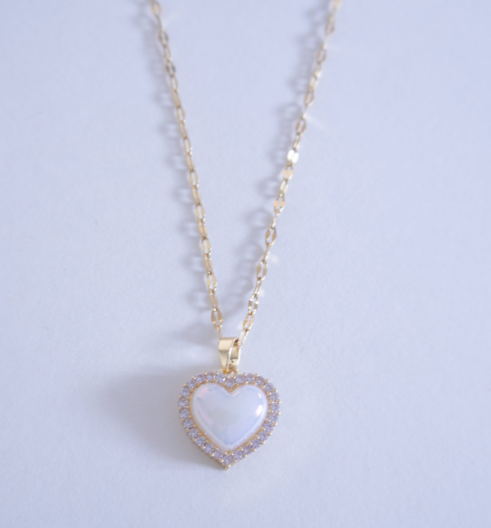 Heart-shaped pendant necklace on a light purple background