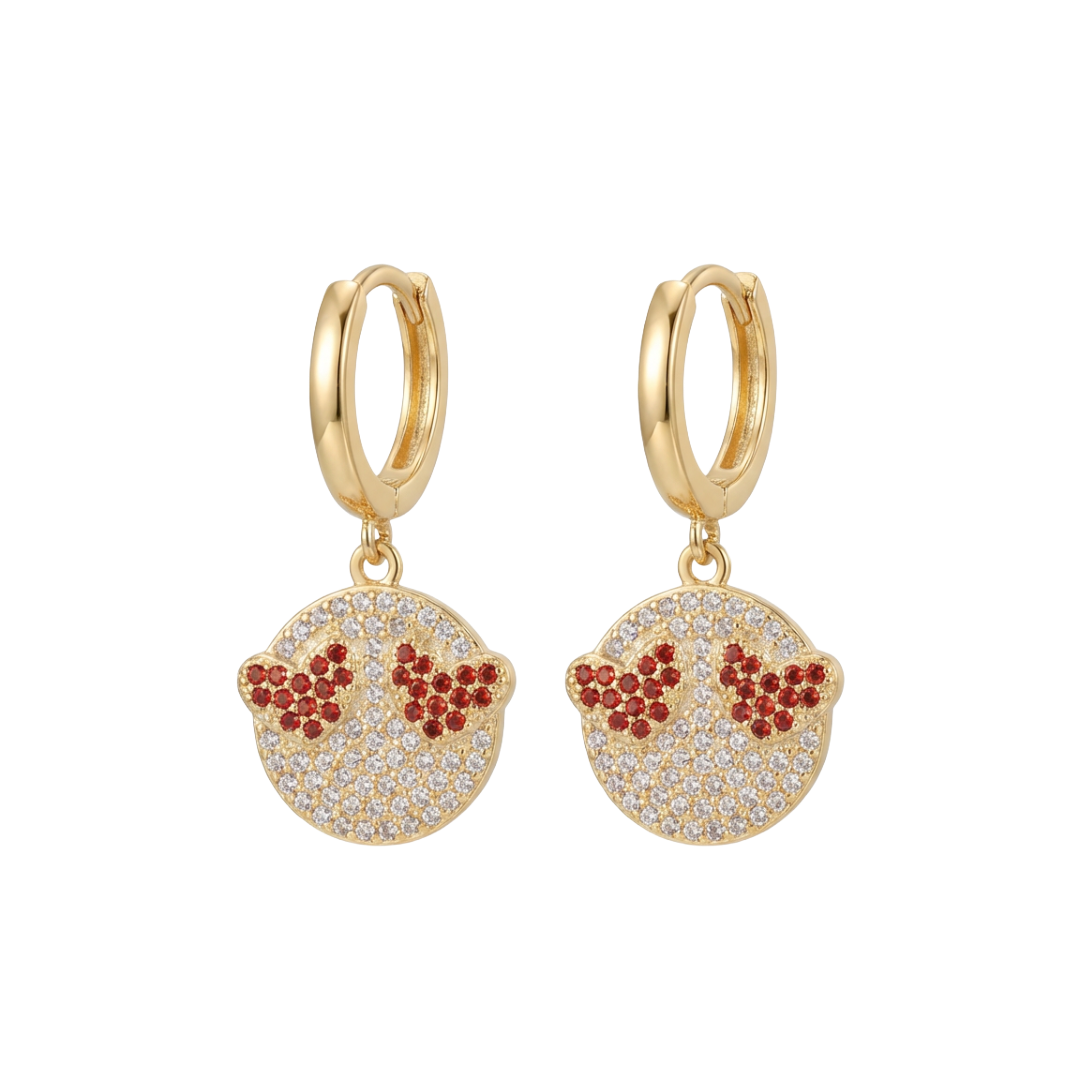 Gold hoop earrings with red and clear gemstone details on a white background
