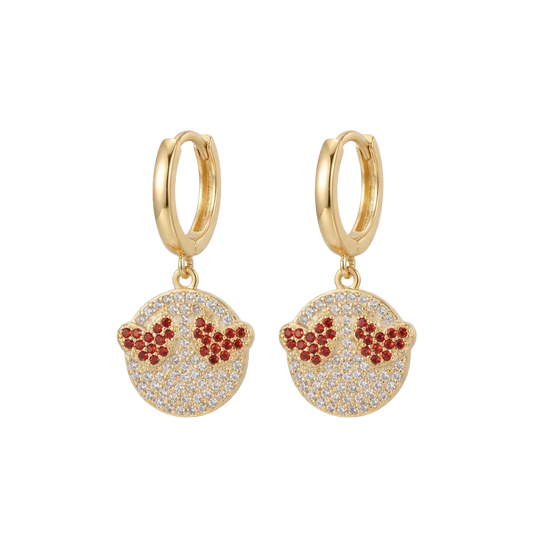 Gold hoop earrings with red and clear gemstone details on a white background
