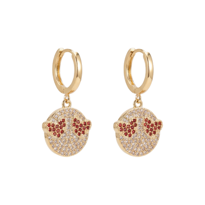 Gold hoop earrings with circular charms featuring red and clear stones on a white background