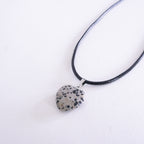 Necklace with a dalmatian jasper pendant on a white background