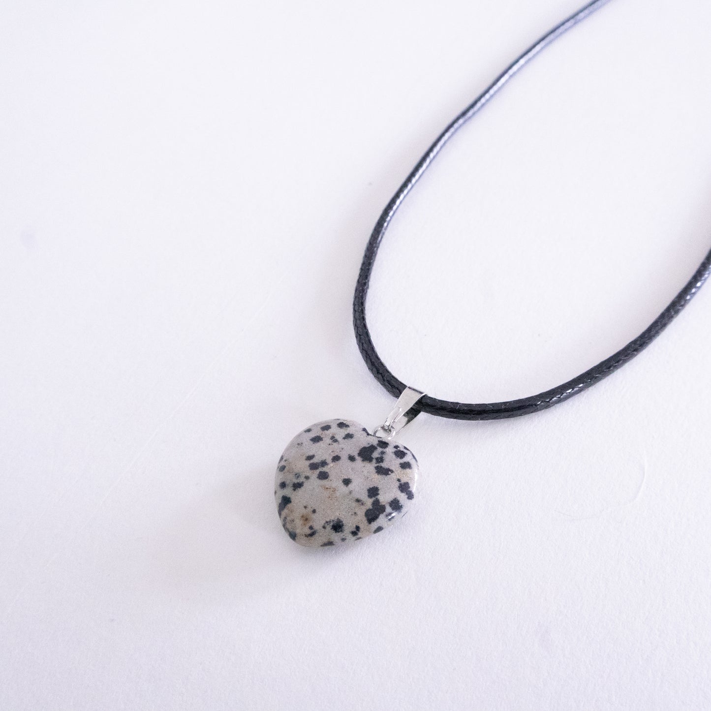 Necklace with a dalmatian jasper pendant on a white background