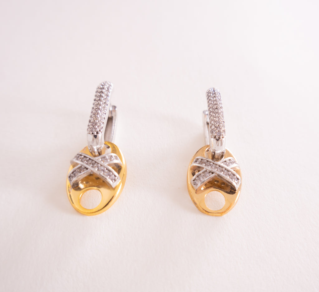Pair of gold and silver earrings on a light background