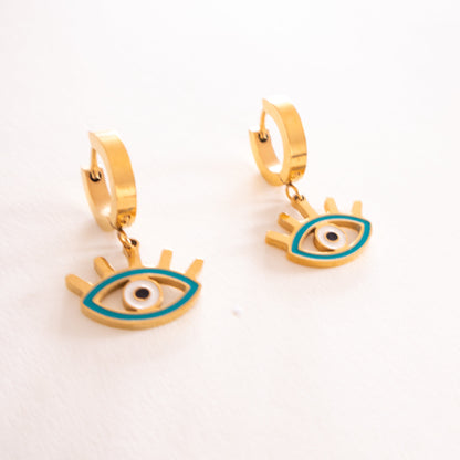Gold hoop earrings with eye design on a white background