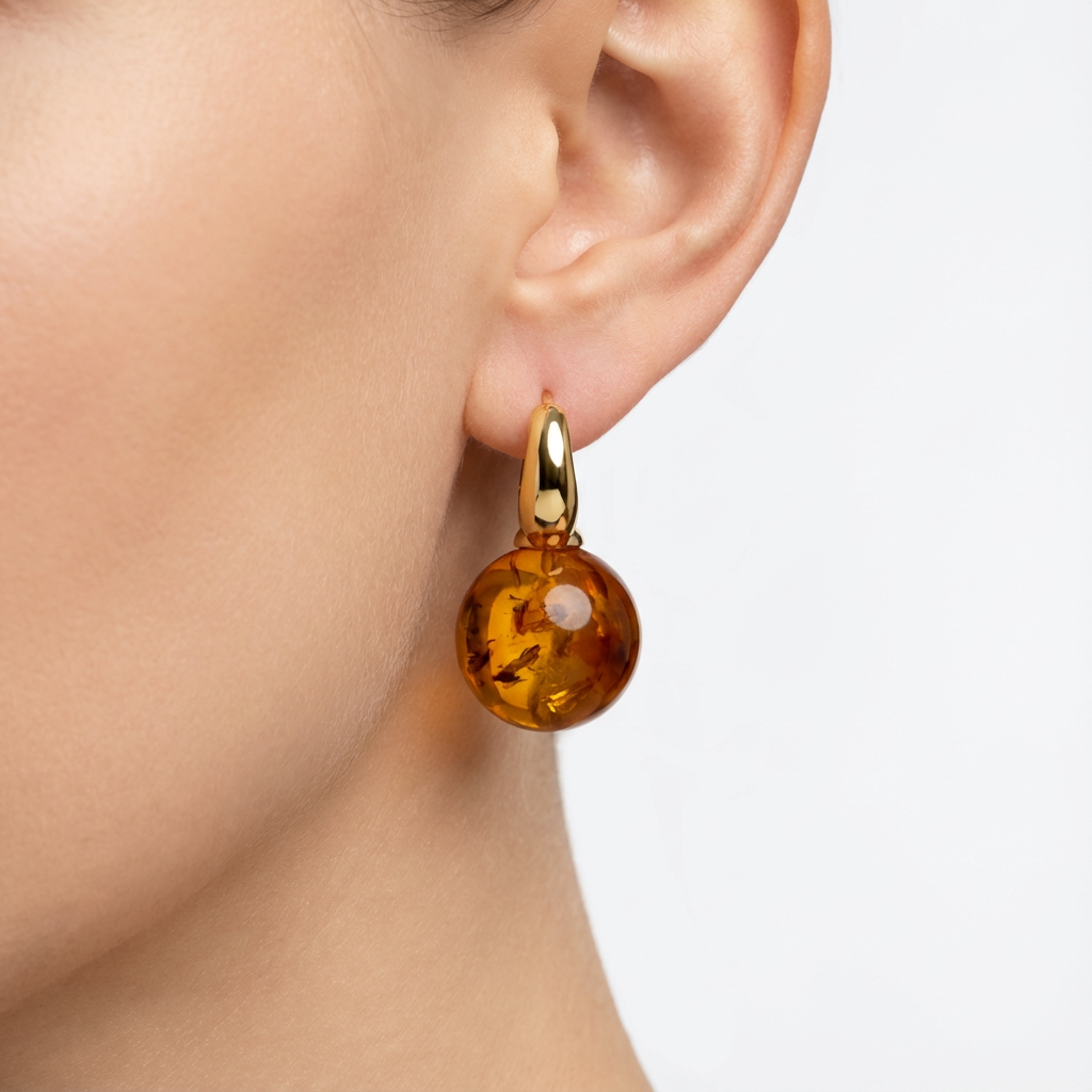 Amber earring on a model's ear with a plain background