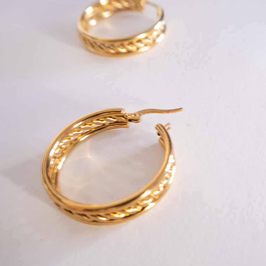 Gold hoop earrings on a light gray background