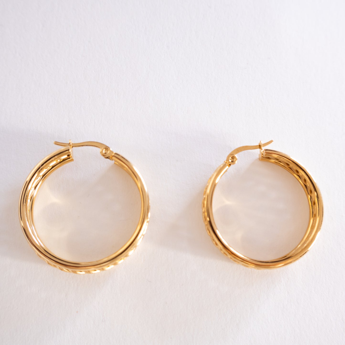 Gold hoop earrings on a light gray background