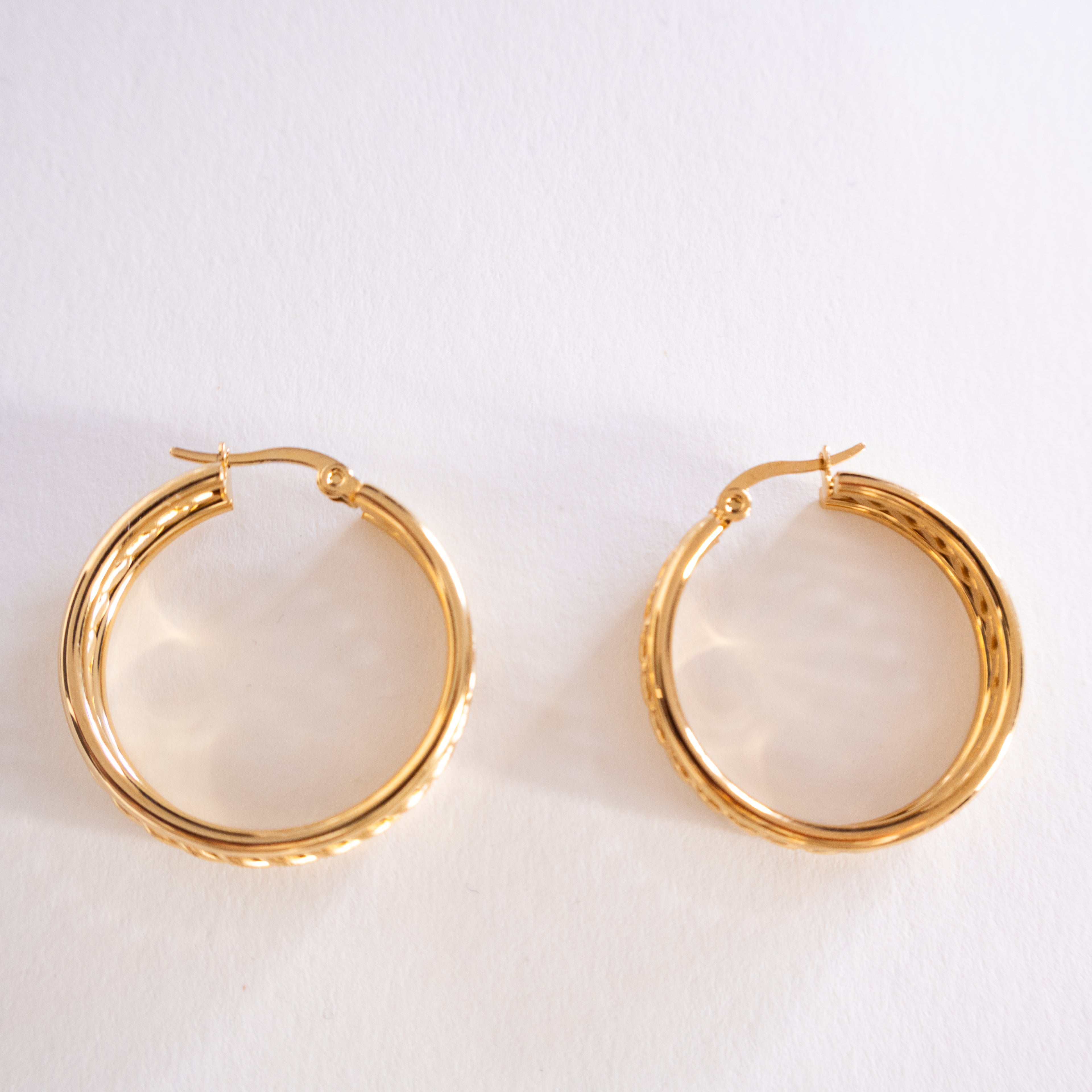 Gold hoop earrings on a light gray background
