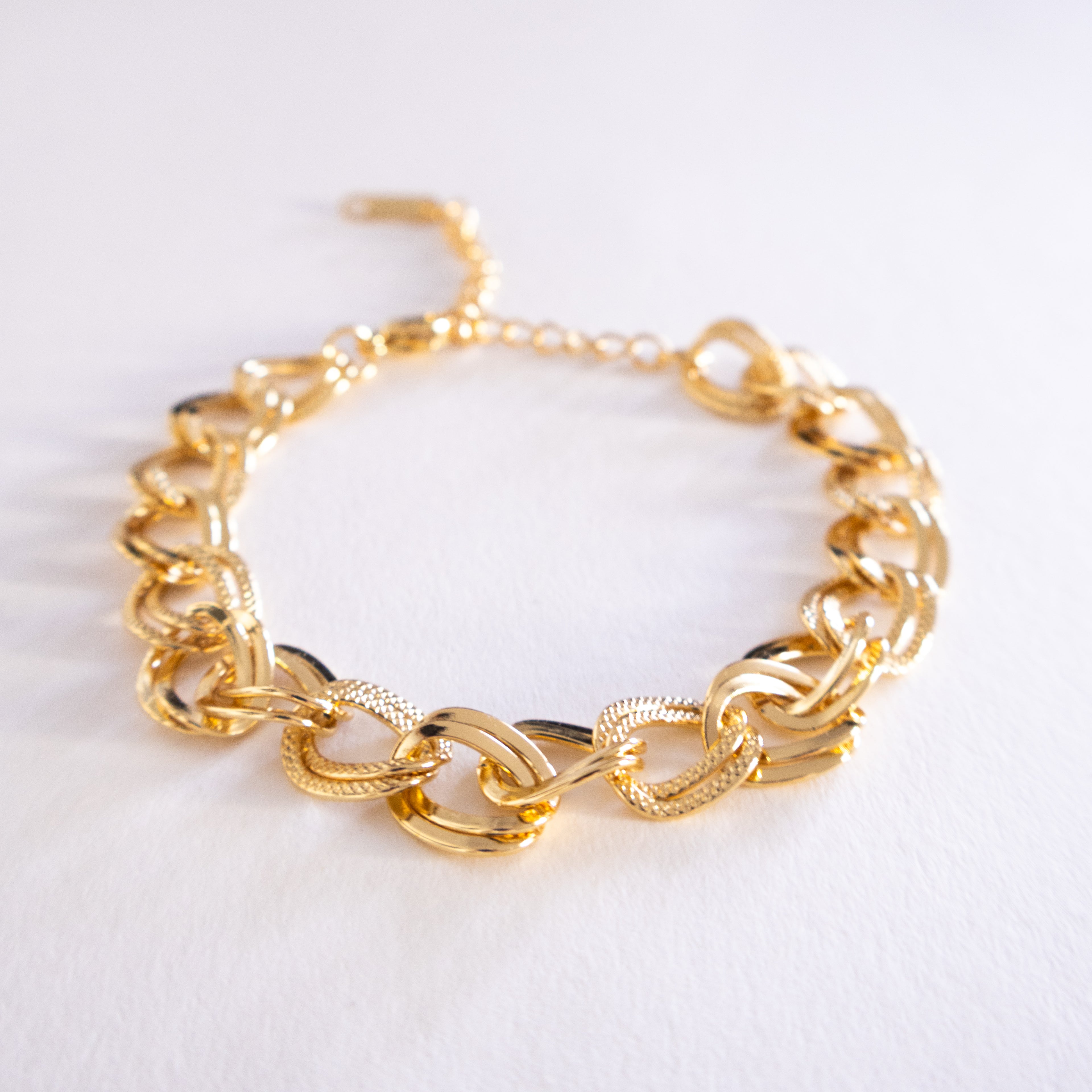 Gold chain bracelet on a white background