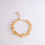 Gold chain bracelet on a light gray background