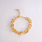 Gold chain bracelet on a light gray background