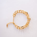 Gold chain bracelet on a light gray background
