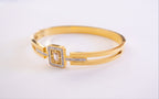 Gold bracelet with a square design on a white background