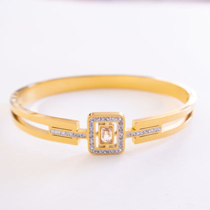 Gold bracelet with a square clasp on a white background