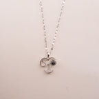 Heart-shaped pendant necklace with 'LOVE' engraving on a beige background