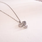 Silver necklace with a unique pendant on a light pink background