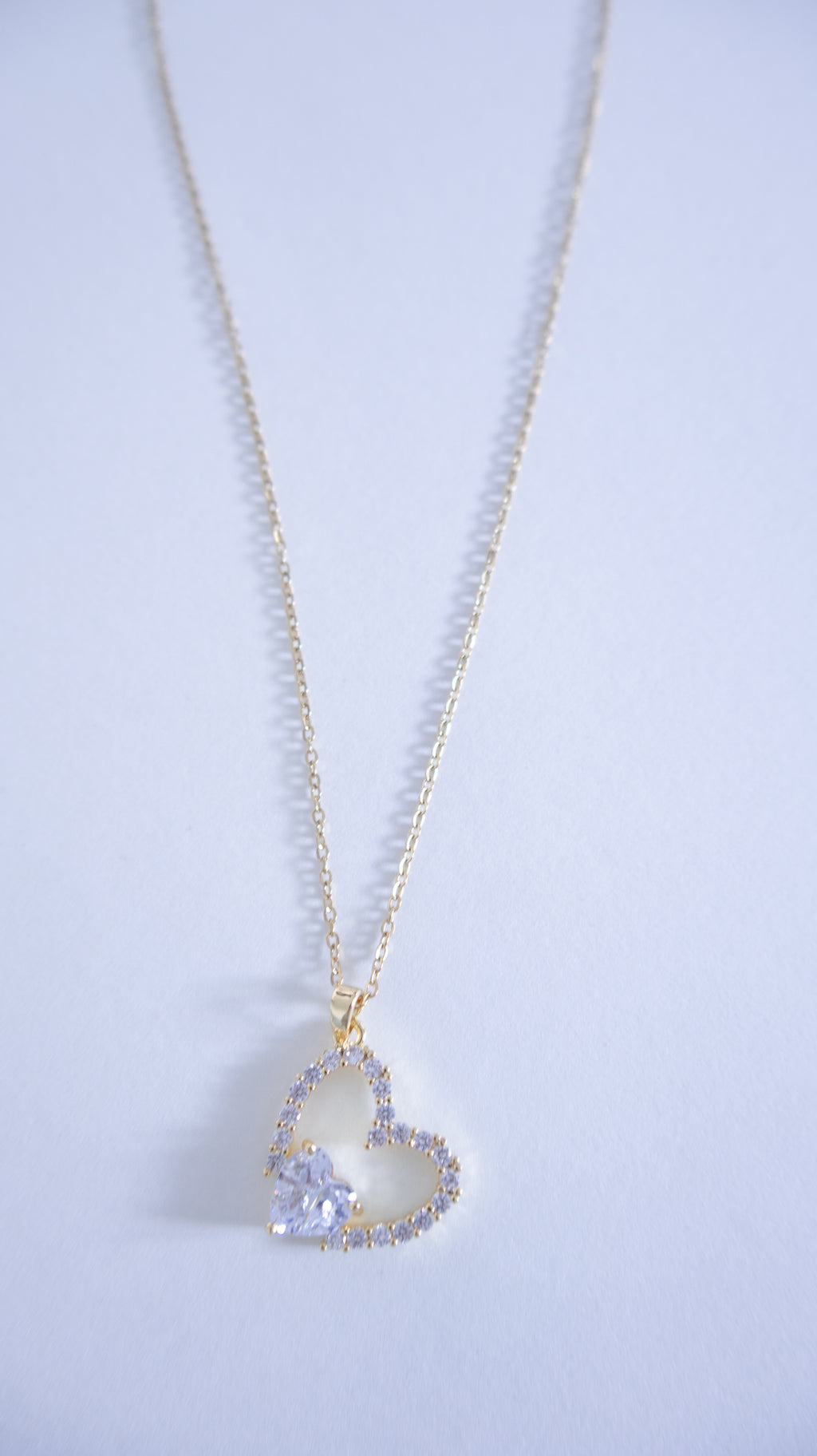 Heart-shaped pendant necklace on a light gray background