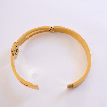 Gold bracaltes necklace on a white background