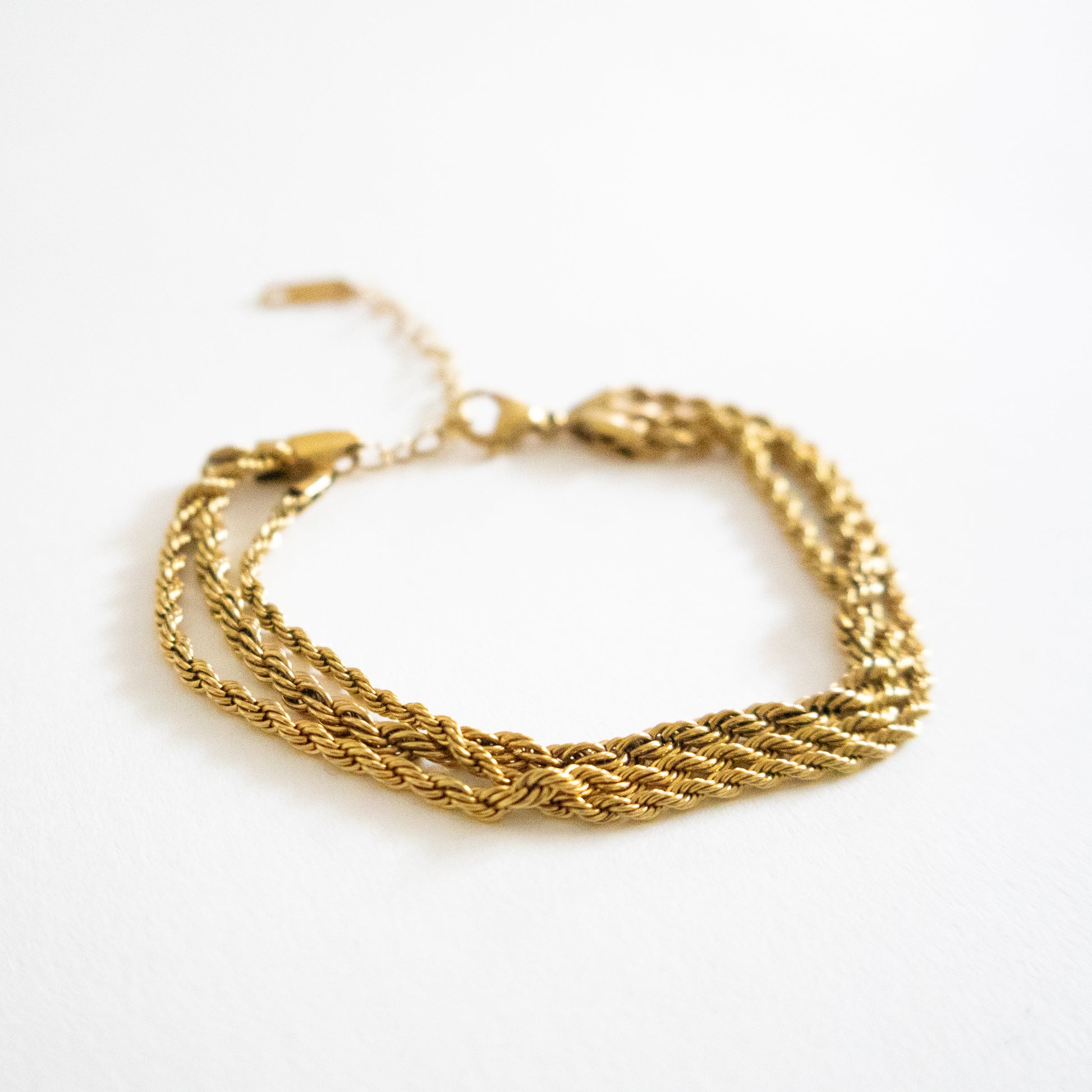 Gold braided bracelet on a white background