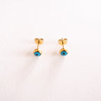 Gold earrings with blue stones on a white background