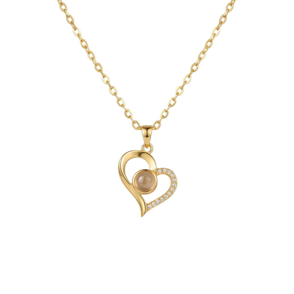 Gold heart-shaped necklace with a pearl center on a white background