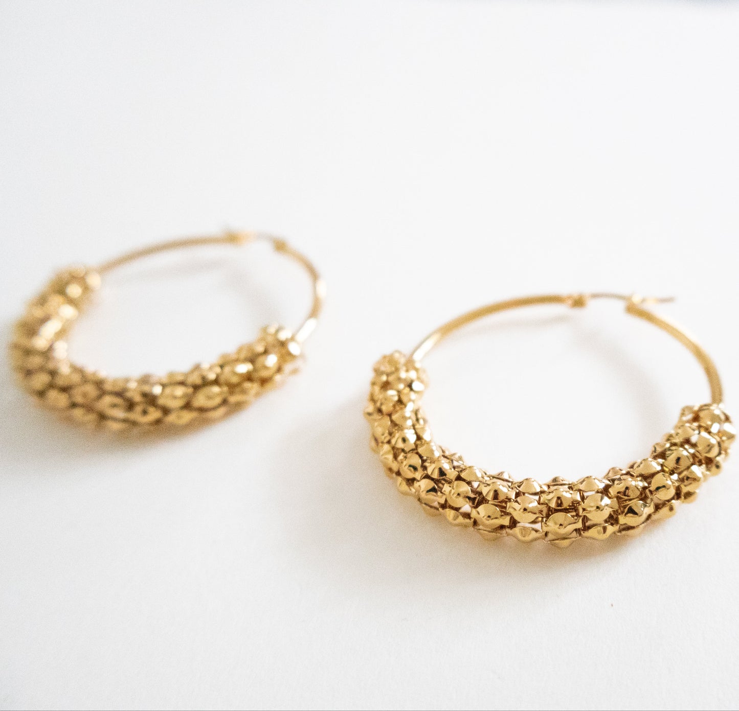Gold hoop earrings on a white background